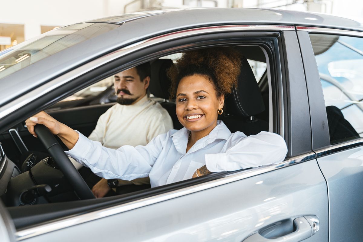 Un couple au volant d'une voiture d'occasion qu'il vient d'acheter