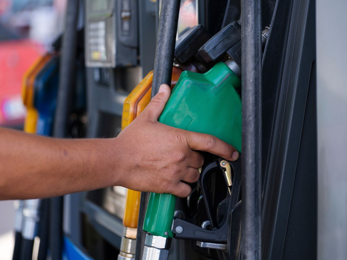 Main saisissant un pistolet de pompe à carburant