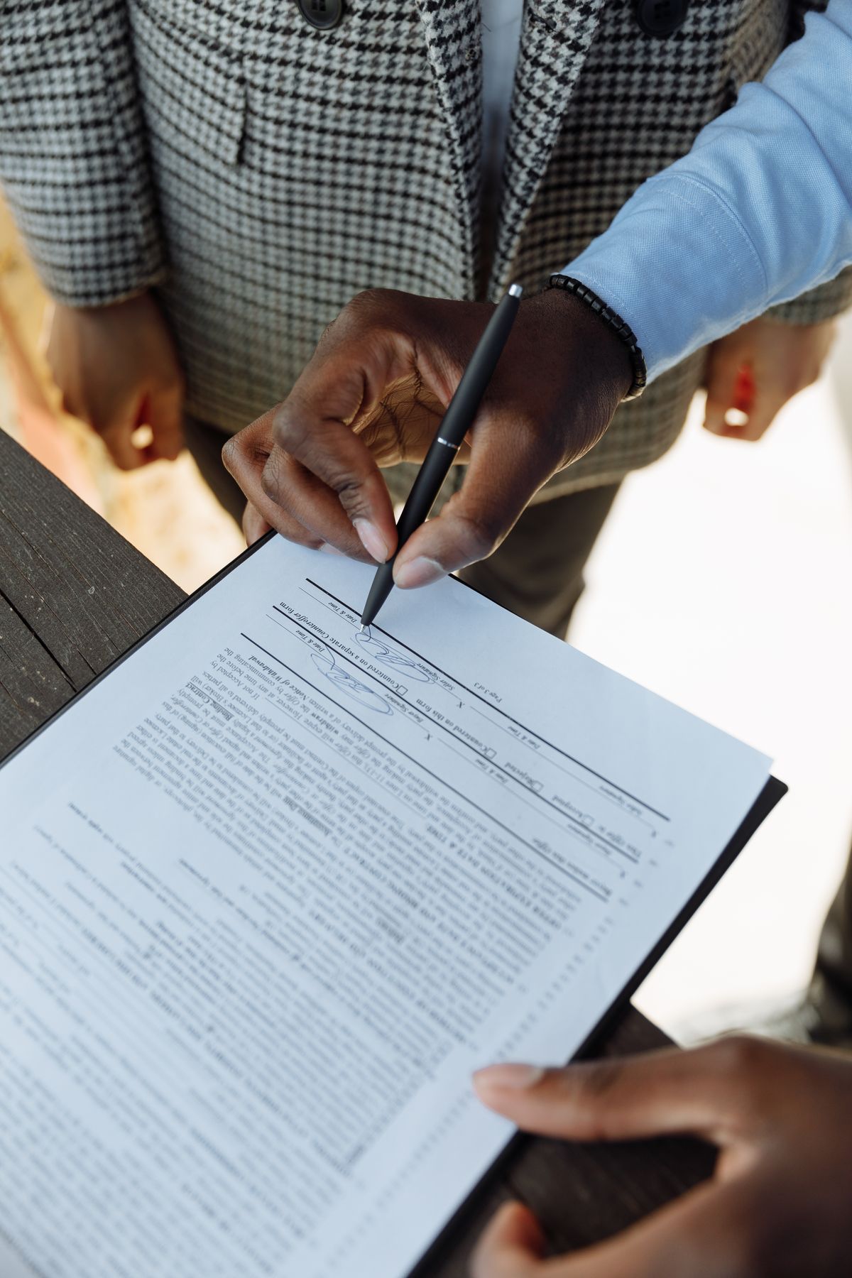 Personne signant un document contractuel avec un stylo